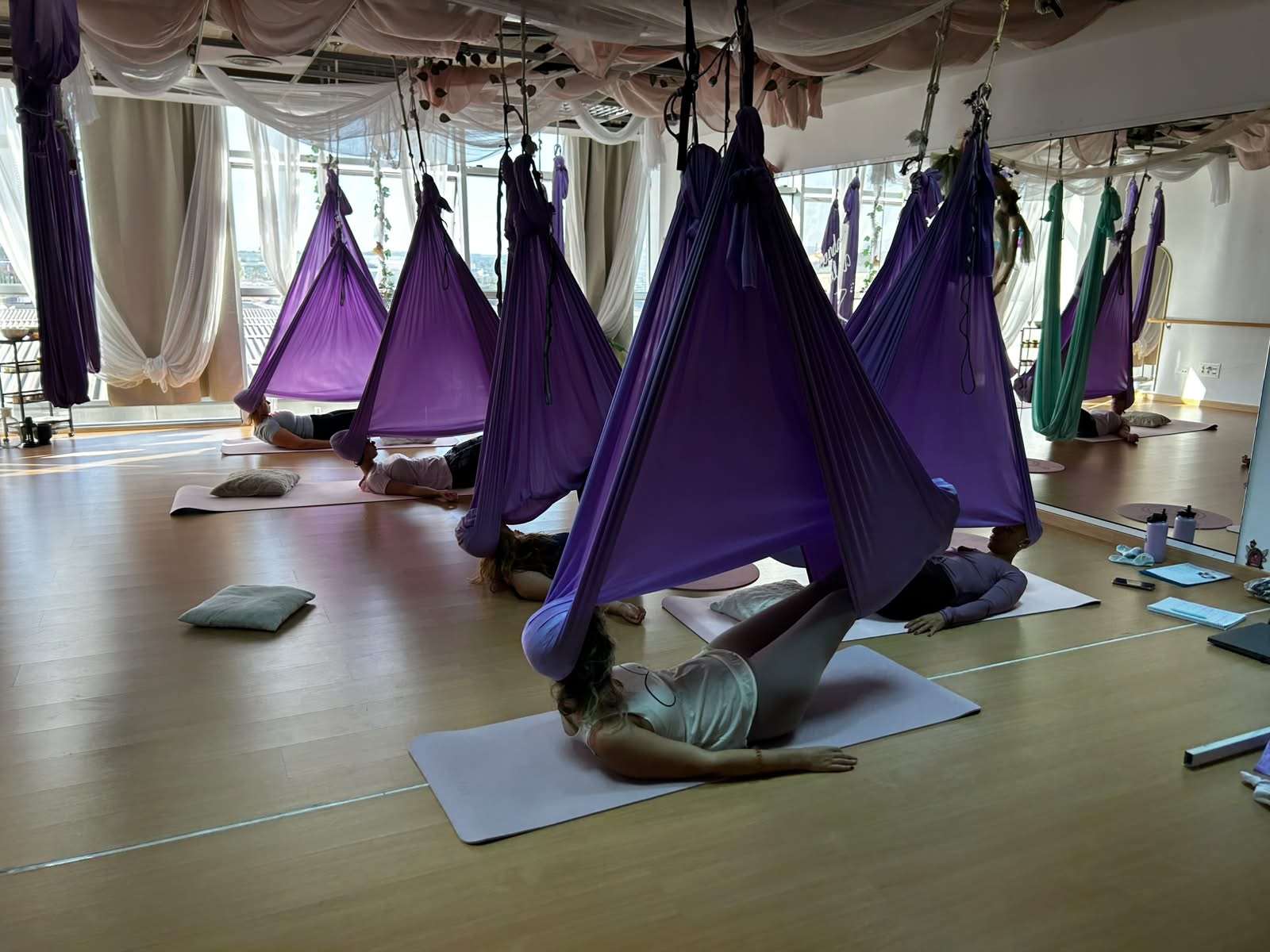 Grupo en relajación tumbado bajo columpios lilas